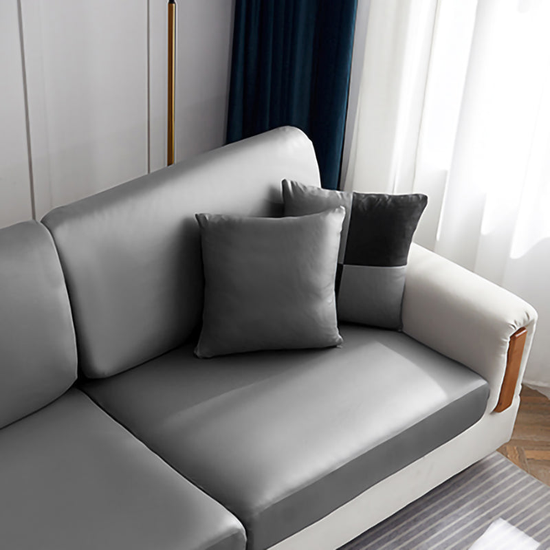 Housse de coussin en simili cuir 40×40, à l'unité, Gris galet, posée sur un canapé
