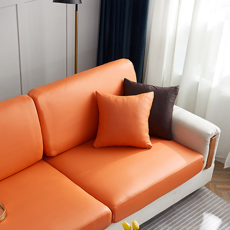 Housse de coussin en simili cuir 40×40, à l'unité, Mandarine, posée sur un canapé