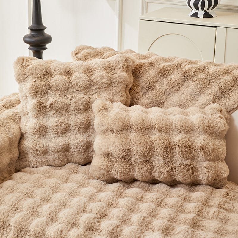 Housse de coussin EasyCover fausse fourrure molletonnée 45×45, à l'unité, Beige camel bulles, posée sur un canapé