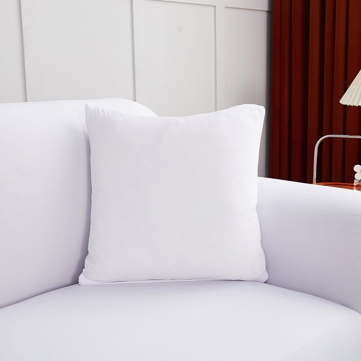Housses de coussin extensibles 45×45, lot de 2, Blanc, posée sur un canapé