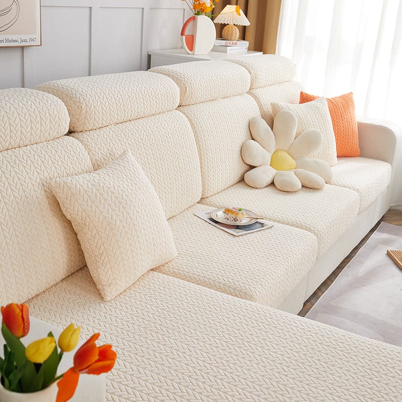 Housse de coussin polaire 45×45, à l'unité, Blanc cassé épis, posée sur un canapé