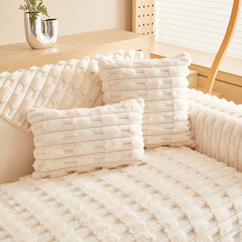 Housse de coussin EasyCover fausse fourrure épaisse 45×45, à l'unité, Blanc crème pavés, posée sur un canapé