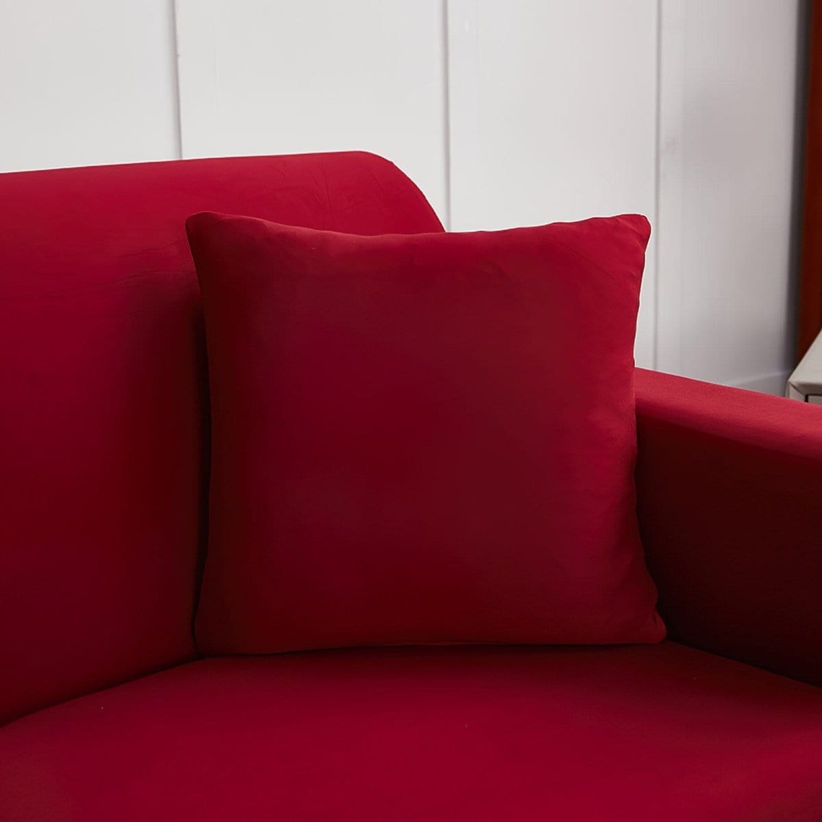 Housses de coussin extensibles 45×45, lot de 2, Bordeaux, posée sur un canapé