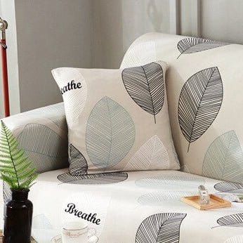 Housses de coussin extensibles 45×45, lot de 2, Écru feuillage gris, posée sur un canapé
