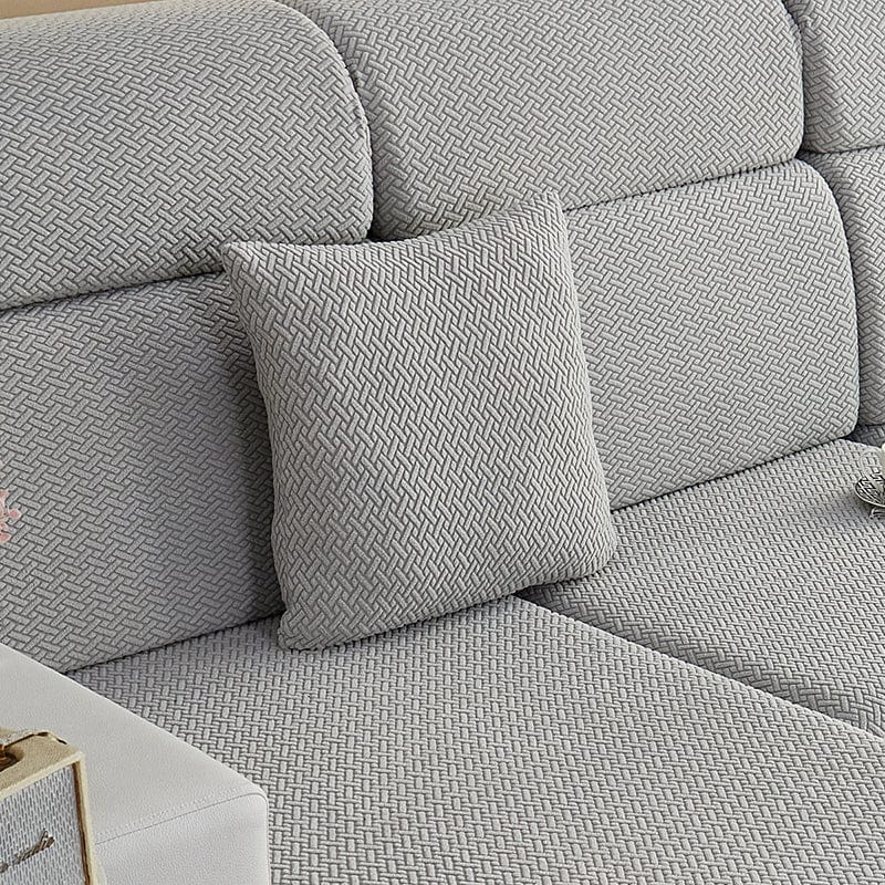 Housse de coussin polaire 45×45, à l'unité, Gris clair natté, posée sur un canapé