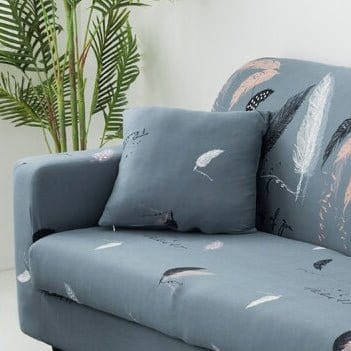 Housses de coussin extensibles 45×45, lot de 2, Bleu gris plumes, posée sur un canapé