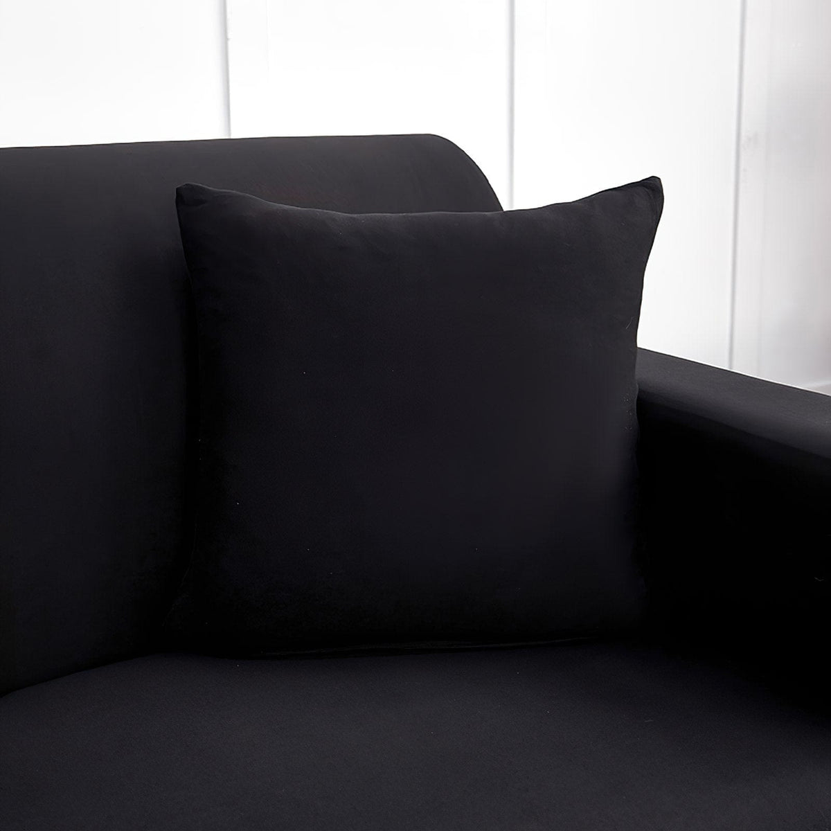 Housses de coussin extensibles 45×45, lot de 2, Noir, posée sur un canapé