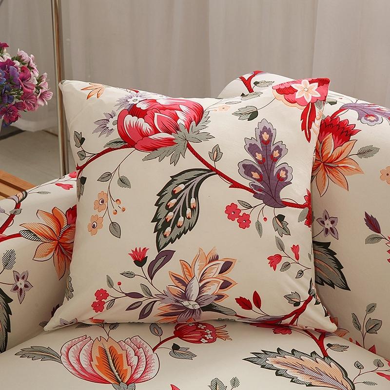 Housses de coussin extensibles 45×45, lot de 2, Écru fleuri rouge, posée sur un canapé