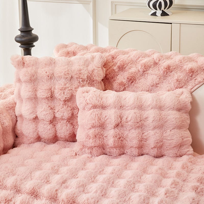 Housse de coussin EasyCover fausse fourrure molletonnée 45×45, à l'unité, Rose bulles, posée sur un canapé