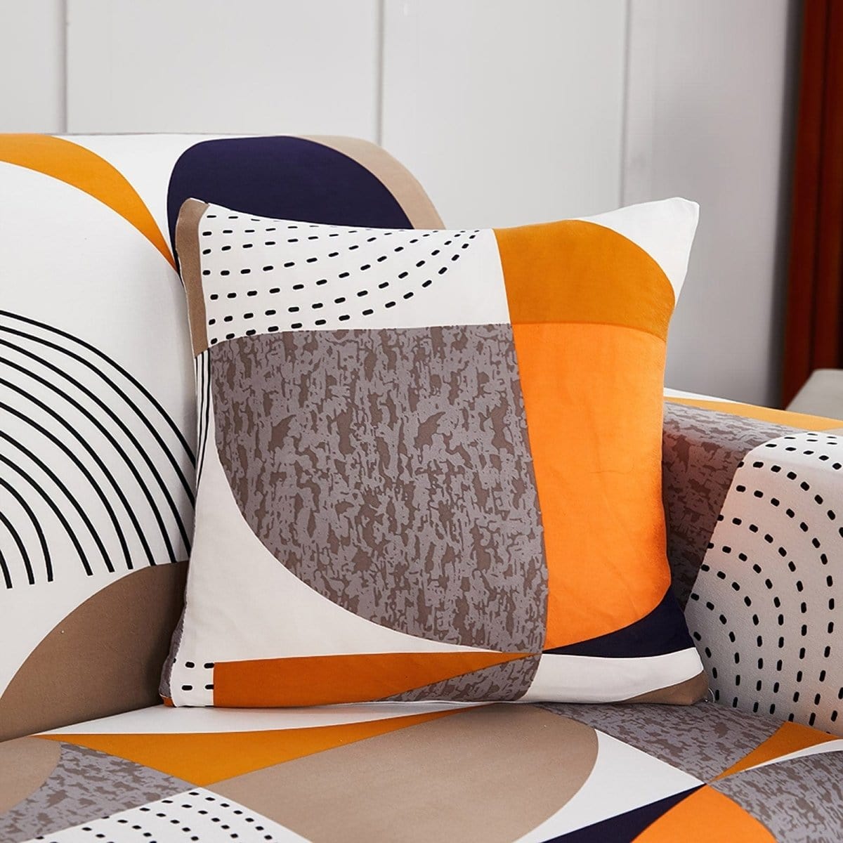 Housses de coussin extensibles 45×45, lot de 2, Patchwork orange et noir, posée sur un canapé