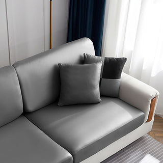 Housse de coussin en simili cuir 40×40, à l'unité, Gris galet, posée sur un canapé