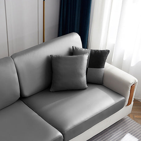 Housse de coussin en simili cuir 40×40, à l'unité, Gris galet, posée sur un canapé