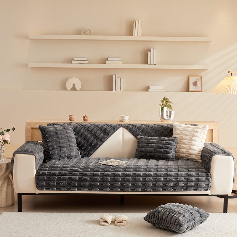 Housse de canapé EasyCover fausse fourrure épaisse, Gris foncé pavés, posée sur un canapé