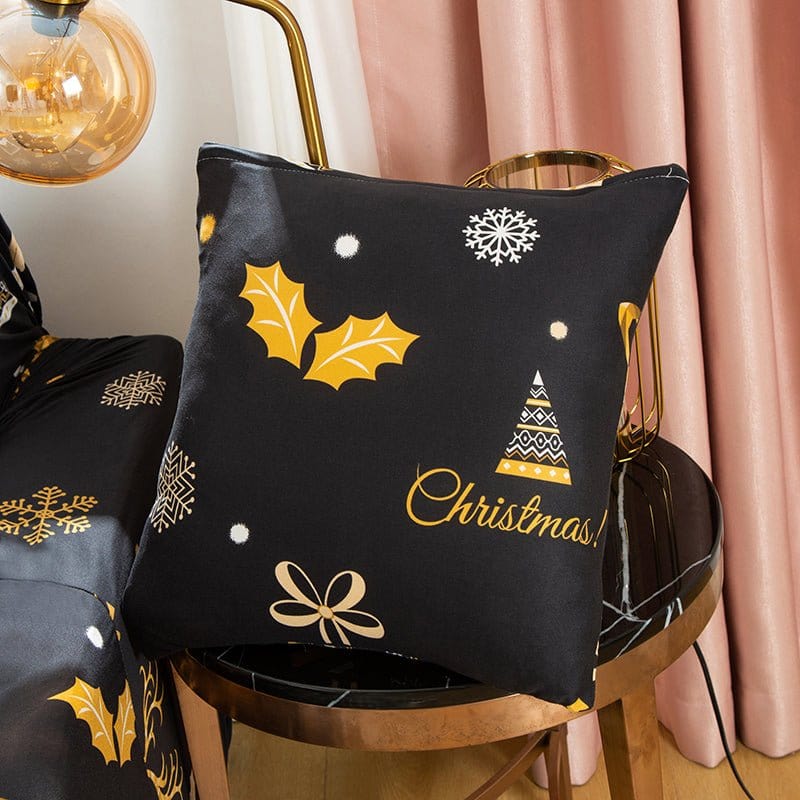 Housses de coussin de Noël 45×45, lot de 2, Noir rennes dorés, posée sur un tabouret