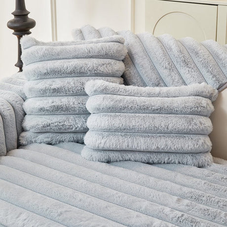 Housse de coussin EasyCover fausse fourrure 45×45, à l'unité, Bleu bandes, posée sur un canapé
