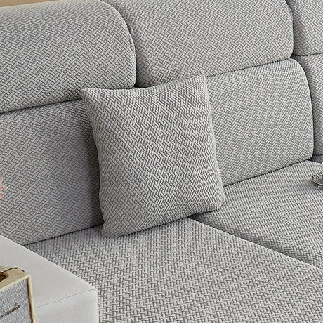 Housse de coussin polaire 45×45, à l'unité, Gris clair natté, posée sur un canapé