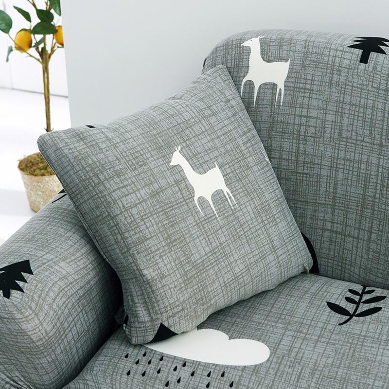 Housses de coussin de Noël 45×45, lot de 2, Gris renne et sapins, posée sur un canapé